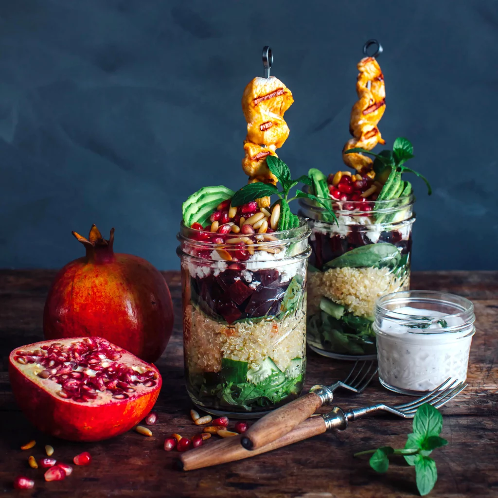 Salada em camadas com quinoa e romã Arremate para a nossa próxima receita de energia: nossa salada em camadas de quinoa e romã com espetos de frango e molho de iogurte de menta caseiro é super refrescante e sem glúten!